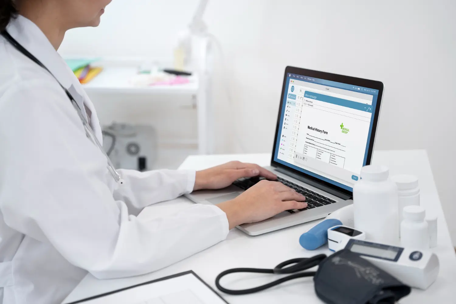 Médica escrevendo sobre histórico de paciente em prontuário eletrônico integrado em computador.